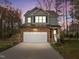 Charming two-story home featuring stone accents, attached two-car garage, and landscaped front yard at 1404 Vanguard Pl, Durham, NC 27713