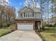 Charming two-story home featuring stone accents, attached two-car garage, and landscaped front yard at 1404 Vanguard Pl, Durham, NC 27713