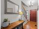 Inviting foyer featuring a wooden console table, elegant mirror, staircase with iron railings, and stylish light fixture at 1404 Vanguard Pl, Durham, NC 27713