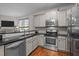 Modern kitchen featuring stainless steel appliances, granite countertops, and white subway tile backsplash at 1404 Vanguard Pl, Durham, NC 27713