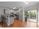 Bright, open kitchen featuring an island, hardwood floors, and sliding door access to the outdoor deck at 1404 Vanguard Pl, Durham, NC 27713