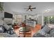 Spacious living room with a fireplace, hardwood floors, ceiling fan, and access to the kitchen and dining area at 1404 Vanguard Pl, Durham, NC 27713