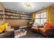 Stylish home office with custom shelving, a built-in desk, and comfortable seating at 1404 Vanguard Pl, Durham, NC 27713