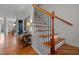Elegant staircase with wood treads and black iron balusters, complemented by hardwood floors and natural light at 1404 Vanguard Pl, Durham, NC 27713