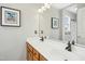 Bathroom with double sinks, wooden cabinets, and decorative framed artwork at 1421 Harvey Johnson Rd, Raleigh, NC 27603