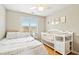Bedroom with a large window, ceiling fan, hardwood floors, and baby crib at 1421 Harvey Johnson Rd, Raleigh, NC 27603