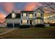 Charming two-story home with blue shutters, a two-car garage, and a beautifully landscaped front yard at dusk at 1421 Harvey Johnson Rd, Raleigh, NC 27603
