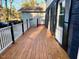 Outdoor wood porch features white railings, providing a cozy space for relaxation and entertainment at 1517 Peace St, Henderson, NC 27536