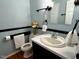 Small bathroom with a vessel sink, white towels, and blue walls at 1517 Peace St, Henderson, NC 27536