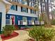 Charming two-story home featuring a bright red front door, a white porch railing, and neatly landscaped greenery at 1517 Peace St, Henderson, NC 27536