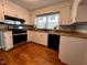 Well-lit kitchen features stainless steel appliances, wooden floors, and ample cabinet space at 1517 Peace St, Henderson, NC 27536