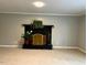 Living room with a fireplace, tan carpet, and neutral-colored walls at 1517 Peace St, Henderson, NC 27536