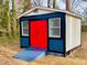 Colorful shed with double doors, ramp, and windows for additional storage space at 1517 Peace St, Henderson, NC 27536