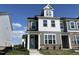Charming, new construction two-story home with stone accents, a quaint porch, and vibrant blue front door at 1573 Wendell Valley Blvd, Wendell, NC 27591