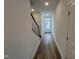 Hallway with dark-stained banister and wood-look flooring leading to a well-lit front entry at 1573 Wendell Valley Blvd, Wendell, NC 27591