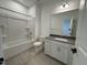 Bright bathroom features a shower-tub combination and white vanity with gray countertop at 1581 Wendell Valley Blvd, Wendell, NC 27591
