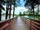 Picturesque view of a lake with a fountain, surrounded by lush greenery and a wooden walkway at 1581 Wendell Valley Blvd, Wendell, NC 27591