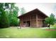 A covered outdoor pavilion with pink chairs is set on lush green lawn surrounded by trees at 1581 Wendell Valley Blvd, Wendell, NC 27591