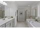 Luxurious bathroom with double vanity, large shower, soaking tub, and neutral tile floors at 163 English Violet Lane Ln, Raleigh, NC 27610