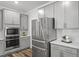 Contemporary kitchen featuring grey cabinets, stainless steel appliances and subway tile backsplash at 163 English Violet Lane Ln, Raleigh, NC 27610