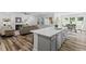 Modern open-concept kitchen with a large island, stainless appliances, and adjacent living area at 163 English Violet Lane Ln, Raleigh, NC 27610
