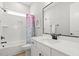 Bright bathroom features a single vanity, tub with tiled surround and colorful curtain at 1737 Fence Post Rd, Wendell, NC 27591