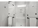 Modern tiled shower with glass door features a built-in bench and convenient towel bars at 1737 Fence Post Rd, Wendell, NC 27591