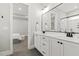 Bright bathroom features a double vanity with white cabinets, black fixtures and a large mirror at 1737 Fence Post Rd, Wendell, NC 27591