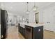 Open concept kitchen with island, black appliances, and hardwood floors throughout at 1737 Fence Post Rd, Wendell, NC 27591