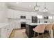 Modern kitchen with white cabinets, black appliances, and stylish bar seating at 1737 Fence Post Rd, Wendell, NC 27591