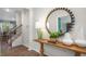Welcoming foyer featuring a wooden console table, decorative mirror, and an open staircase at 176 Ethel Ln, Angier, NC 27501