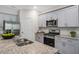 Well-lit kitchen featuring stainless steel appliances, granite countertops, and stylish gray cabinetry at 176 Ethel Ln, Angier, NC 27501