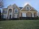 Handsome brick home features a covered entryway, pristine lawn, and classic architectural details at 2000 Falls Farm Crossing Xing, Raleigh, NC 27614
