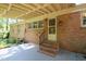 Brick house featuring a covered back patio with a staircase and iron railing at 2201 Knollwood Dr, Sanford, NC 27330