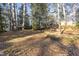 A sprawling yard with mature trees, offering a serene backdrop to this lovely brick home at 2201 Knollwood Dr, Sanford, NC 27330