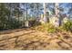 A brick home with a chimney and mature trees offers a serene outdoor space at 2201 Knollwood Dr, Sanford, NC 27330