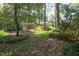 Charming brick home nestled among mature trees with a well-manicured lawn at 2201 Knollwood Dr, Sanford, NC 27330