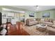 Inviting living room featuring hardwood floors, a neutral sofa, and a view into the modern kitchen at 2201 Knollwood Dr, Sanford, NC 27330