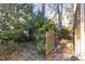 A brick walkway leads through a fenced area and lush, mature landscape at 2201 Knollwood Dr, Sanford, NC 27330