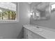 Bright bathroom featuring a single sink vanity, large mirror, natural lighting, and white trim at 2301 Pastille Ln, Raleigh, NC 27612