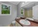 Neutral bathroom with a large vanity mirror, single sink, toilet, and a window view to a leafy yard at 2301 Pastille Ln, Raleigh, NC 27612