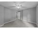 A large gray bedroom has a ceiling fan, neutral carpet and baseboards, and a connecting bathroom at 2301 Pastille Ln, Raleigh, NC 27612