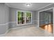 Bright dining room featuring a large window overlooking the fenced backyard and wooded landscape at 2301 Pastille Ln, Raleigh, NC 27612