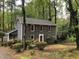 Charming two-story home featuring gray siding, red shutters, well-manicured landscaping, and a backdrop of lush trees at 2301 Pastille Ln, Raleigh, NC 27612