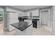 Bright kitchen featuring white cabinetry, black appliances, black marble counters, and tiled floor at 2301 Pastille Ln, Raleigh, NC 27612