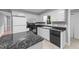 Bright kitchen featuring white cabinets, black appliances, and an island with a granite countertop at 2301 Pastille Ln, Raleigh, NC 27612