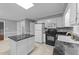 Spacious kitchen with white cabinetry, black appliances, granite countertops, and an island at 2301 Pastille Ln, Raleigh, NC 27612