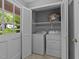 Well-lit laundry room featuring a side by side washer and dryer, storage shelving, and tiled floor at 2301 Pastille Ln, Raleigh, NC 27612