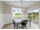Charming dining area with modern lighting, a wooden table, and sliding glass doors to the outdoor patio at 251 Olde Pl, Zebulon, NC 27597