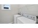 Bright laundry room features a white washer and dryer and shelving at 251 Olde Pl, Zebulon, NC 27597